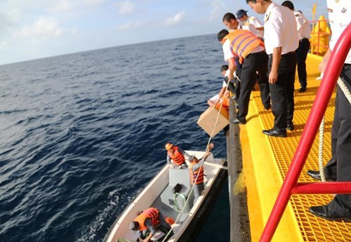 将年货从大船卸下，放入冲锋舟。（图片来源：越南《人民军队报》）