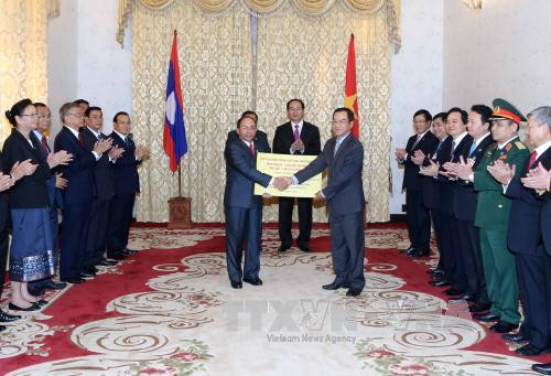  老挝人民革命党中央委员会总书记、国家主席本扬 • 沃拉吉与陈大光主席见证越南在老挝色贡省援建学校的礼物移交仪式。