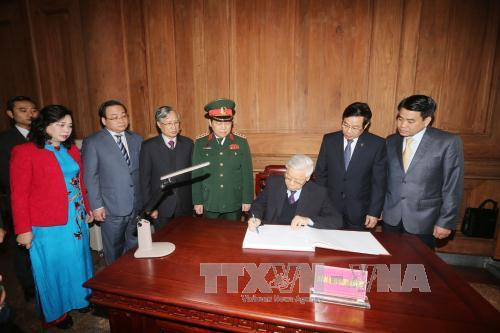  阮富仲总书记在纪念簿上留言。（图片来源：越通社）