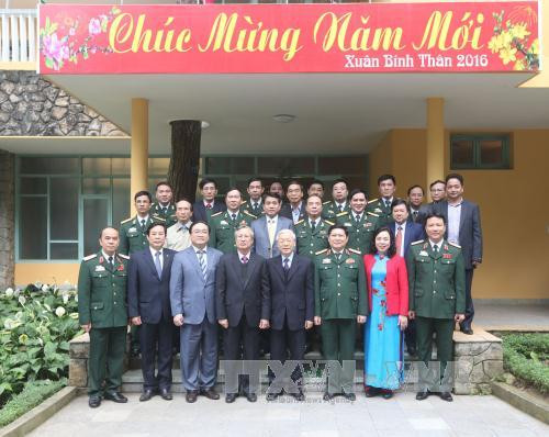  阮富仲总书记与遗迹区干部人员和战士们合影。（图片来源：越通社）