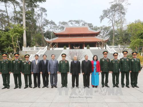  阮富仲总书记与遗迹区干部人员和战士们合影。（图片来源：越通社）