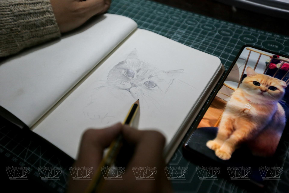 对各种宠物仔细观察后，世武进行手绘设计草图。图自越通社《越南画报》