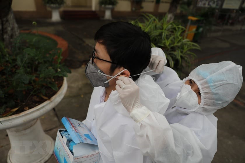 在开始工作之前，工作人员都要穿上防护服和佩戴口罩。越通社记者 青松 摄