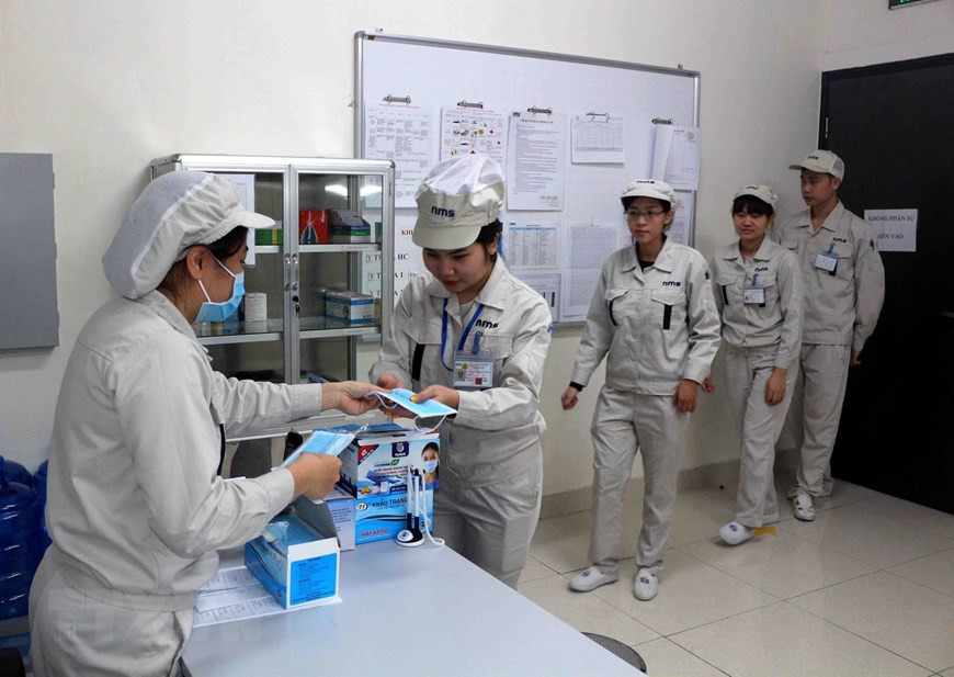 在上班之前，河南省NMS公司均给工人发放一次性卫生口罩。（图自越通社）