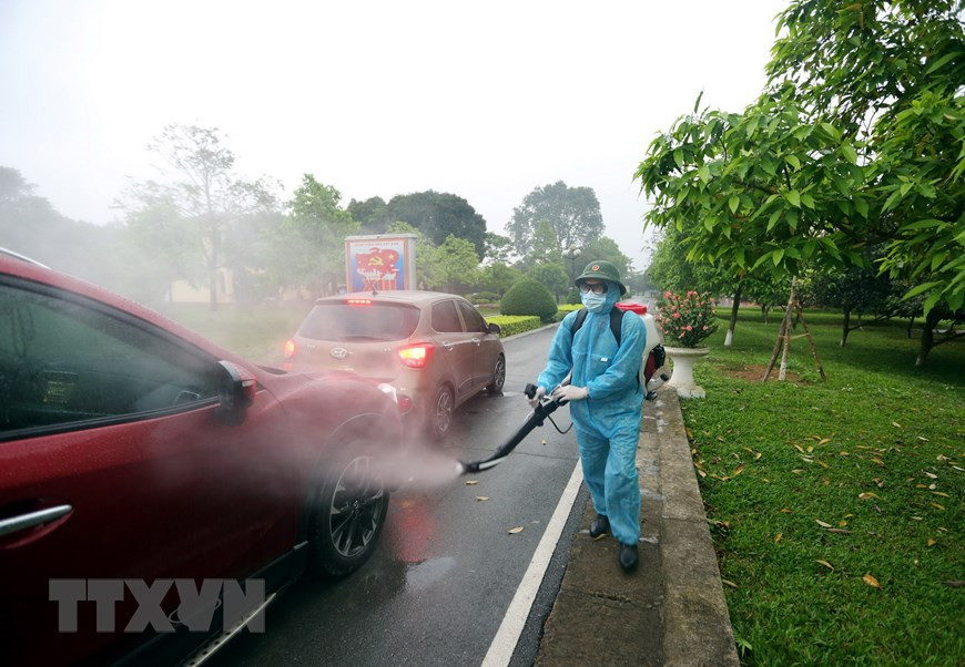  战士向接送公民返乡的车辆进行消毒杀菌。越通社记者 杨江 摄