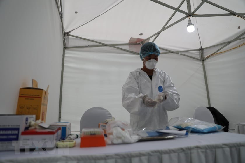 在开始工作之前，工作人员都要穿上防护服和佩戴口罩。越通社记者 青松 摄