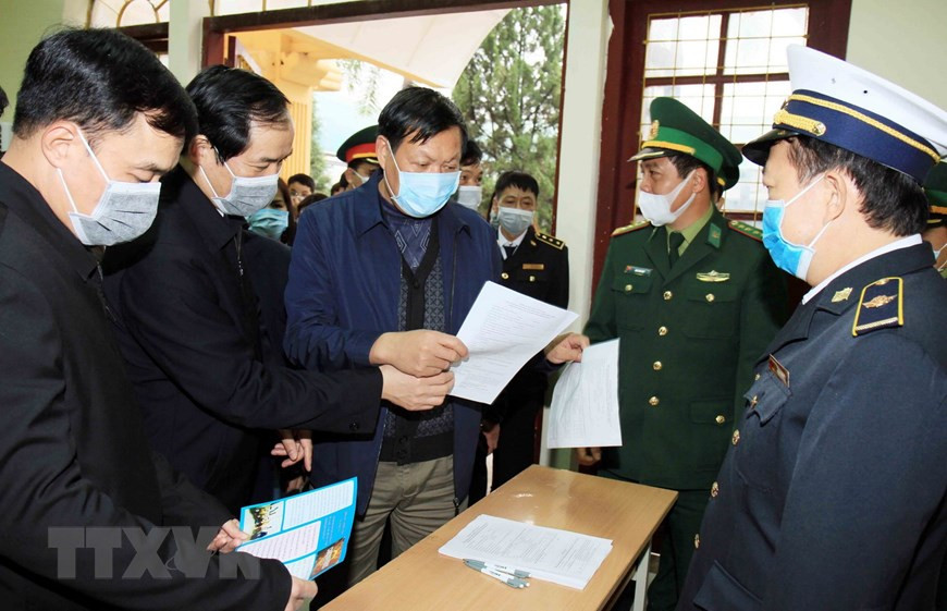 卫生部副部长杜春宣赴谅山省友谊国际口岸检查入境旅客健康状况申报表填写与提交工作。（图自越通社）