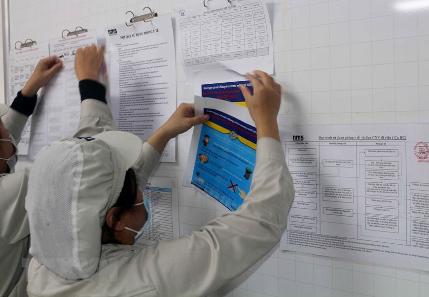 在河南省工业区，工人始终更新新冠肺炎疫情演变情况和防控方法等的相关信息。（图自越通社）