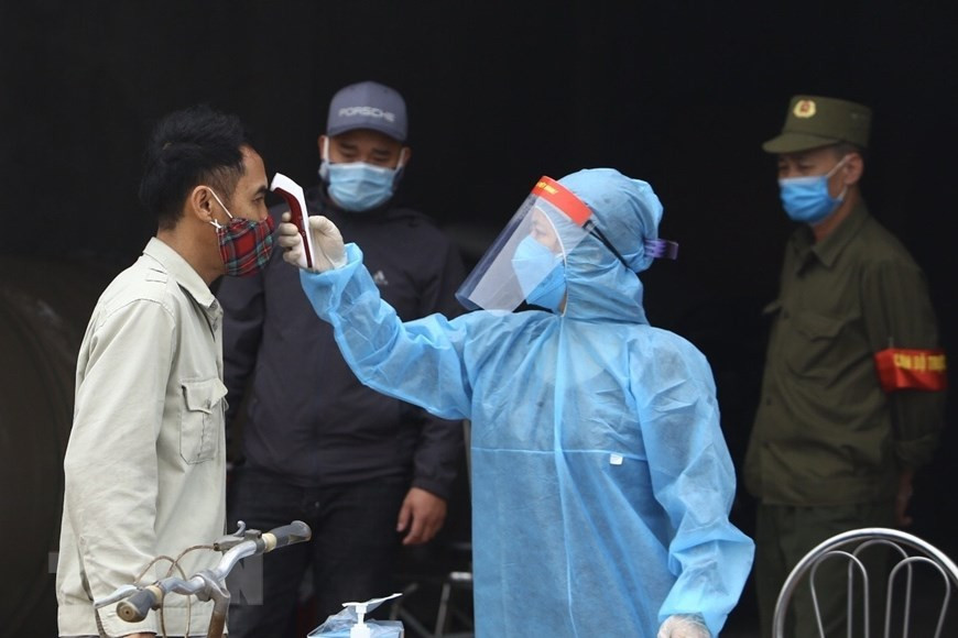 医务人员给东九村人民测量体温。越通社记者 明决 摄