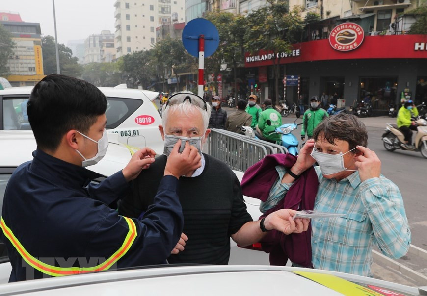来越旅游的外国游客也免费领取医用口罩。（图自越通社）