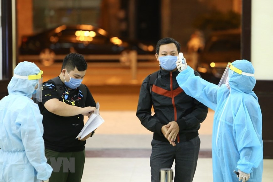 上火车之前，工作人员对所有乘客进行检测体温。（图自越通社）