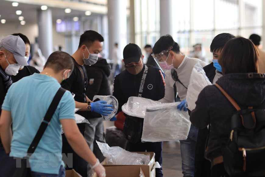 旅居莫斯科的越南志愿者向准备登机的越南公民赠送防护服。越通社记者 陈孝 摄。