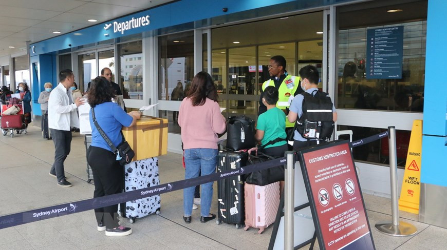 越南公民在悉尼国际机场出示证件办理出境手续。（图自越通社）