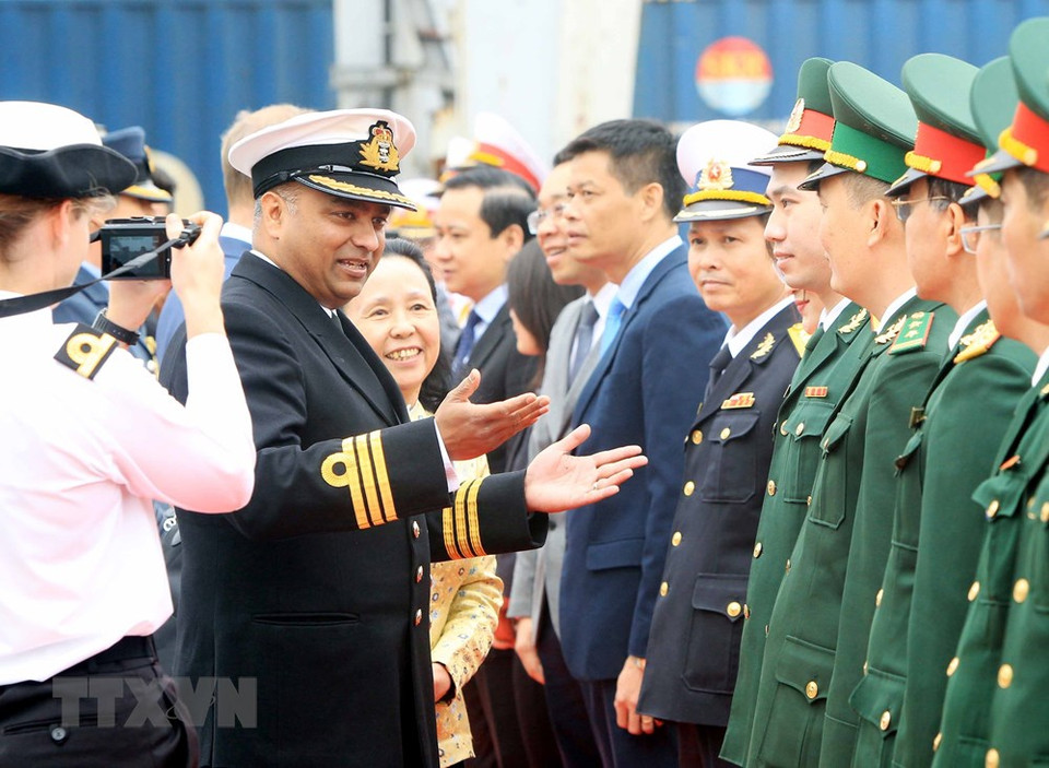 “企业号”海军测量船船长、指挥官塞西尔·拉迪斯劳斯同越南代表团亲切交谈。图自越通社