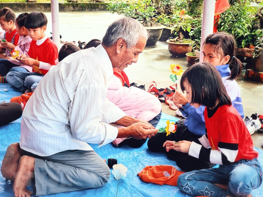 学生们体验纸花制作业，小朋友们已经被数百年历史的纸花制作业所迷住。图自越通社