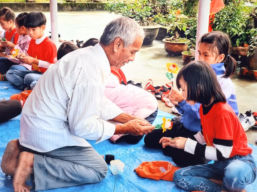 学生们体验纸花制作业，小朋友们已经被数百年历史的纸花制作业所迷住。图自越通社