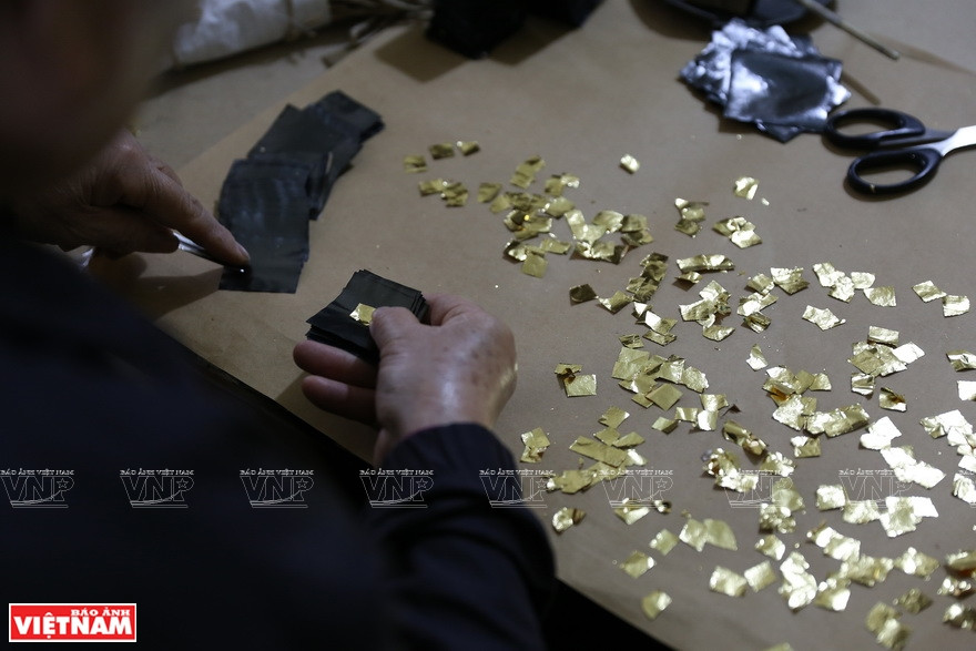 将金箔和金葵一层一层地堆起来。图自越通社