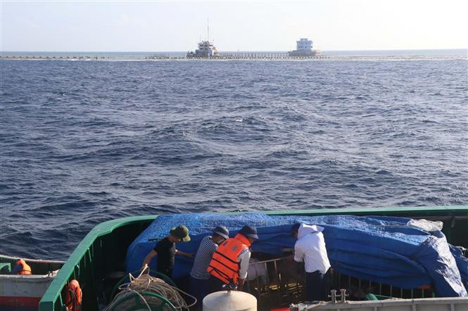 战士们把年货装上船，准备送往长沙群岛。（越通社记者阮文日 摄）