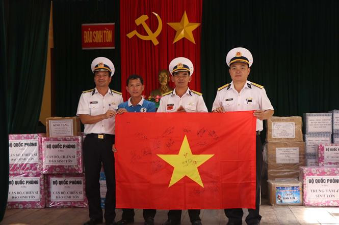 给长沙群岛生存岛军民赠送由越南U22足球队成员在夺得第30届东运会金牌后在五星红旗上签名留念的越南国旗。（越通社记者阮文日 摄）