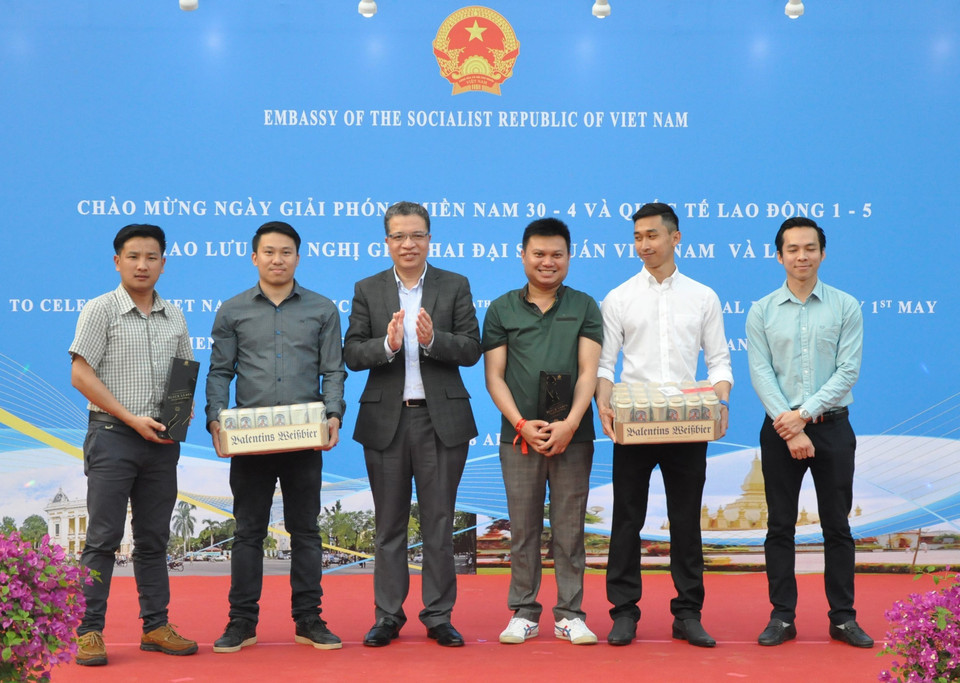 越南驻中国大使邓明魁向老挝驻中国大使馆干部职工赠送礼物。越通社记者 梁俊 摄