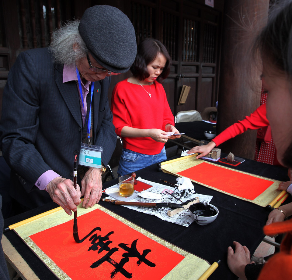 年轻游客请图翁替人写字，希望在新一年里安康、旺盛。越通社记者 国庆 摄