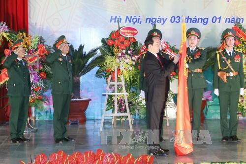 陈大光主席将一级独立勋章别在越南国防学院的传统旗上（图片来源：越通社）