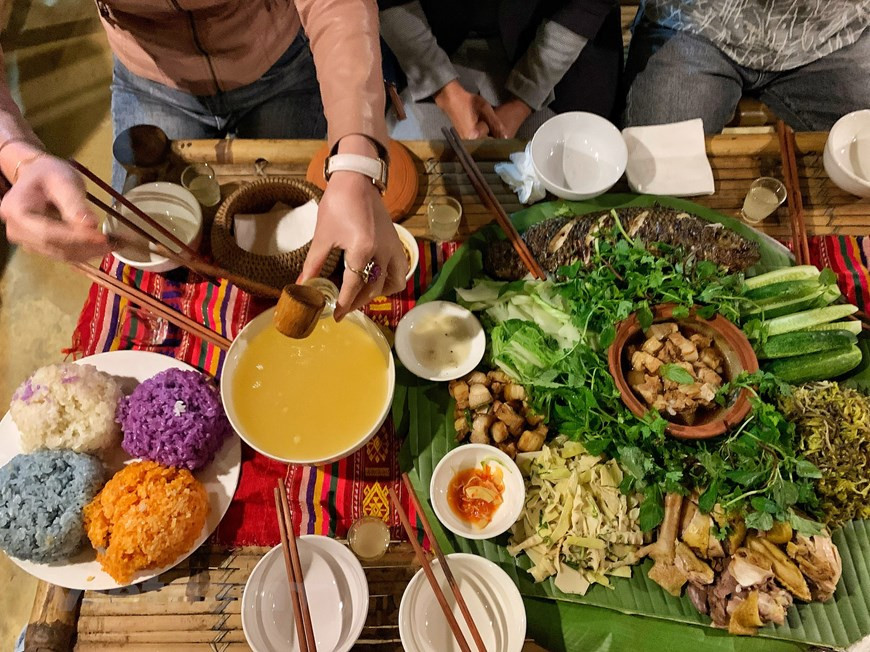 来到石碑村时夜幕已降临，村民打起锣钲迎接游客的到来并后摆着丰盛菜肴招待来宾。游客已有机会品尝了当地芒族人各种特色菜肴，如烤鱼、煮山鸡、酸竹笋凉拌菜、五色糯米饭、烤猪等。这些菜肴都是当地村民自给自足的，特有西北山区的香味。除了菜肴外，酒也是当地的特产，来到这里的游客需品尝的。喝酒后气氛将更加活跃，人们将高唱起来，跳起舞。图自Vietnam+