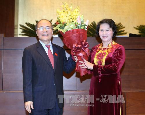 原国会主席阮生雄向新任国会主席阮氏金银赠送鲜花表示祝贺。（图片来源：越通社）