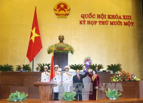 原国会主席阮生雄向新任国会主席阮氏金银赠送鲜花表示祝贺。（图片来源：越通社）