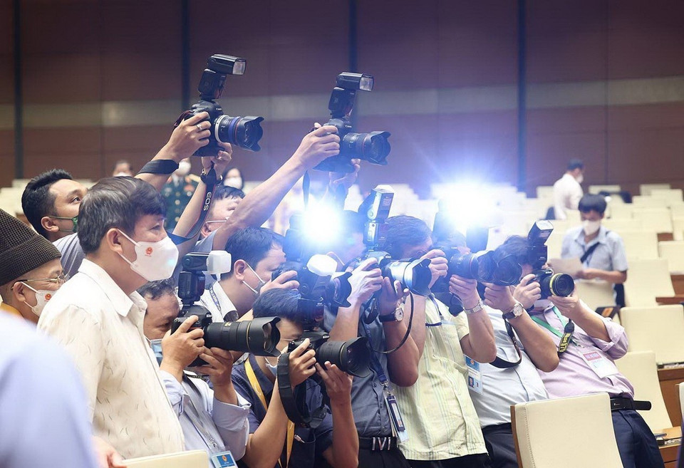 越通社记者在2021年7月召开的第十五届国会第一次会议报道作业。图自越通社