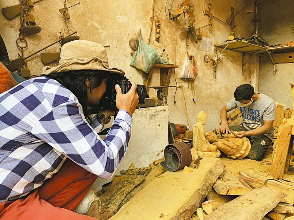 《民族与山区画报》记者安成达记者2022年12月在河内市怀德县山童手工艺村报道作业。图自越通社