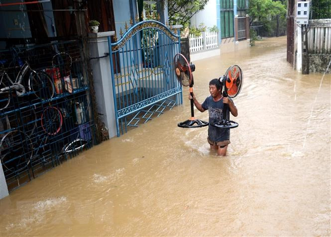 广义省居民要把东西搬到高处，以防止洪水浸泡。图自越通社