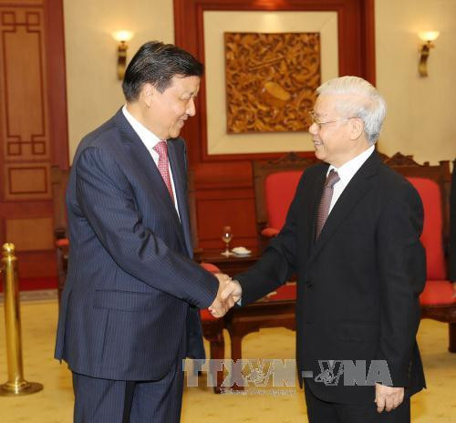 越共中央总书记阮富仲（右）与中共中央政治局常委、中央书记处书记刘云山亲切握手。（图片来源：越通社）