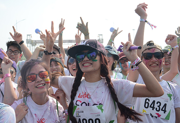 参加者身着白色T恤，跑步过程中经过不同的彩色站，会被从头到脚抛撒彩色粉末。