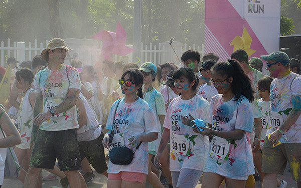 参加者身着白色T恤，跑步过程中经过不同的彩色站，会被从头到脚抛撒彩色粉末。