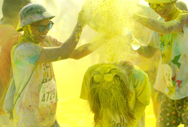 参加者身着白色T恤，跑步过程中经过不同的彩色站，会被从头到脚抛撒彩色粉末。