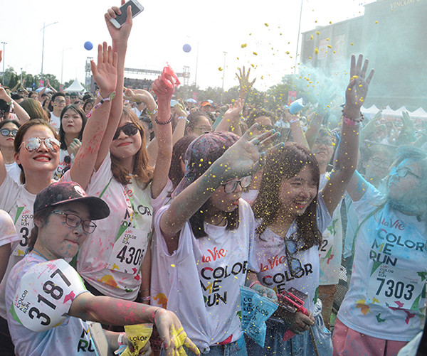 参加者身着白色T恤，跑步过程中经过不同的彩色站，会被从头到脚抛撒彩色粉末。
