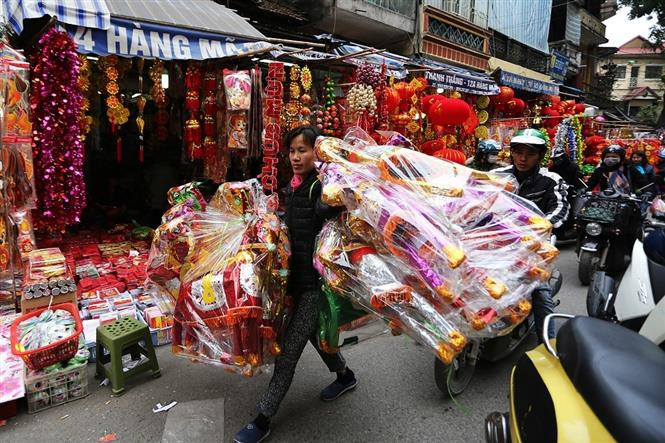 这几天来，马行街人们来往如梭。各商店摆满各种商品，冥品应有尽有，主要包括供奉灶王的纸衣服、帽子、鞋、锡箔、纸钱之类等。（图自：越通社）