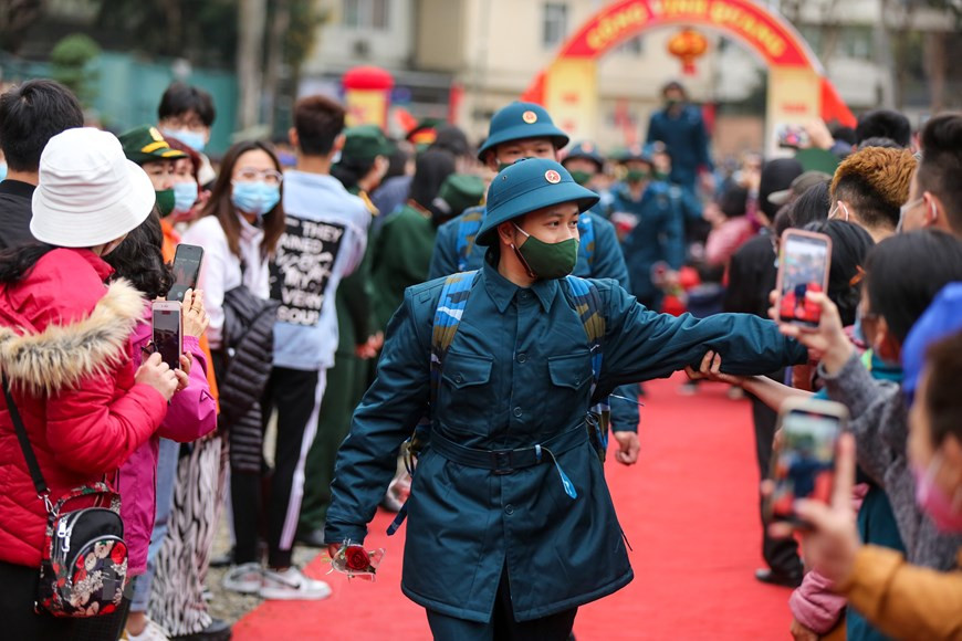 据河内首都司令部的消息，为了确保新冠肺炎疫情防控工作，在新冠肺炎疫情复杂多变的背景下，在举行新兵交接仪式举行之前，河内市已举行新冠病毒采样检测活动。新兵在正式入伍之前要进行测量体温,防止疫情输入军队，确保防疫安全。图自Vietnam+