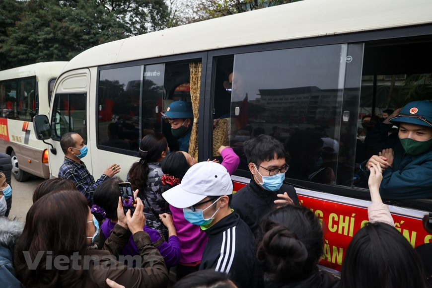 新兵正式入伍之间，必须接受最后一次体温监测。新兵都下决心完成被交给的任务，为建国卫国事业做出积极贡献。当兵光荣，但作为新世纪的青年一代，他们肩上更是担负着重大的责任。在新兵交接仪式上，河内市领导向新兵们赠送鲜花。图自Vietnam+