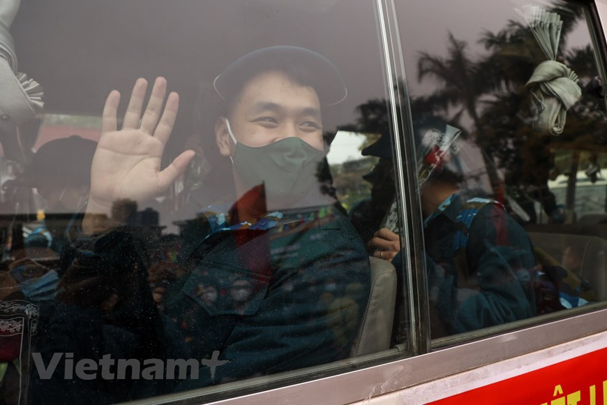 2月27日上午，河内市30个郡、县、镇一律举行2021年度新兵交接仪式暨欢送仪式。在新冠肺炎疫情的形势仍然复杂严峻的背景下，2021年度新兵交接仪式在简便而庄重气氛中进行，严格遵守防疫规定。河内市领导与新兵家属一起欢送新兵奔赴军营。图自Vietnam+