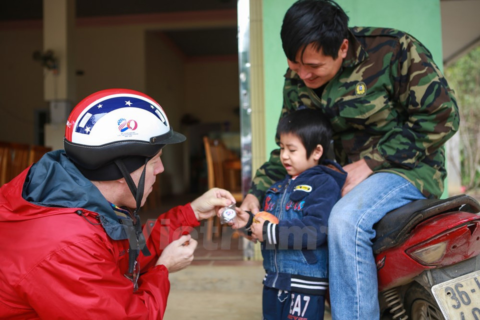 特德奥修斯大使把越美建交20周年纪念徽章送给一个小男孩儿。（图片来源：越通社）