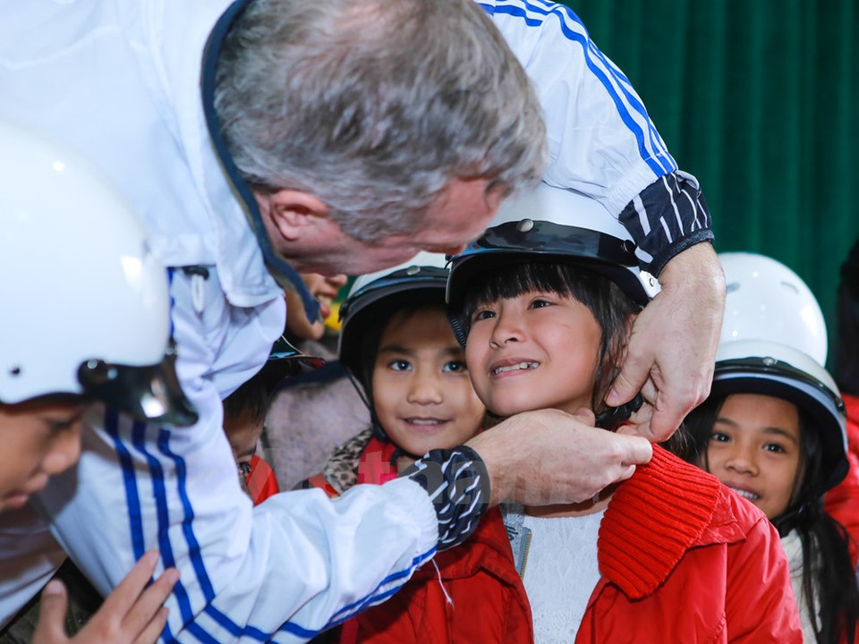 特德奥修斯大使向河静省孤儿村的一个女孩儿赠送安全帽。（图片来源：越通社）