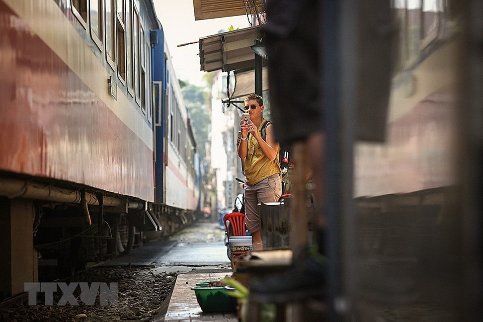 游客们将统一列车进入河内市铁路街道的时刻拍摄下来。越通社记者 仲德 摄