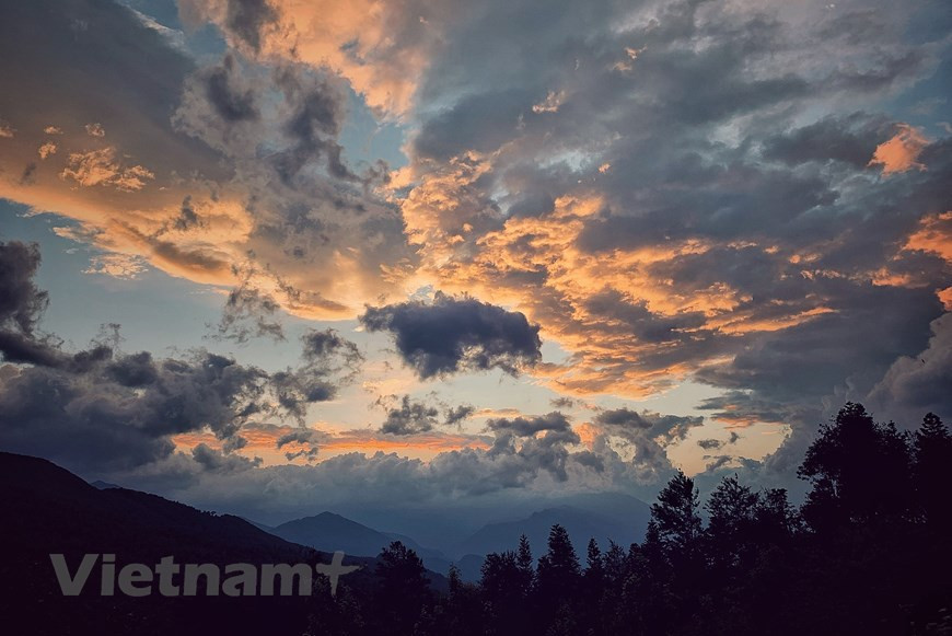 黄昏是美丽的，晚霞如同一片赤红的落叶坠到铺着黄尘的地上，斜阳之下的山冈变成了暗紫色，好像云海之中的礁石。图自越通社