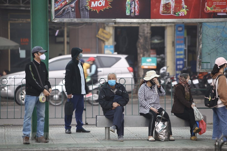 在龙边公车站候车的乘客。（越通社记者明决 摄）