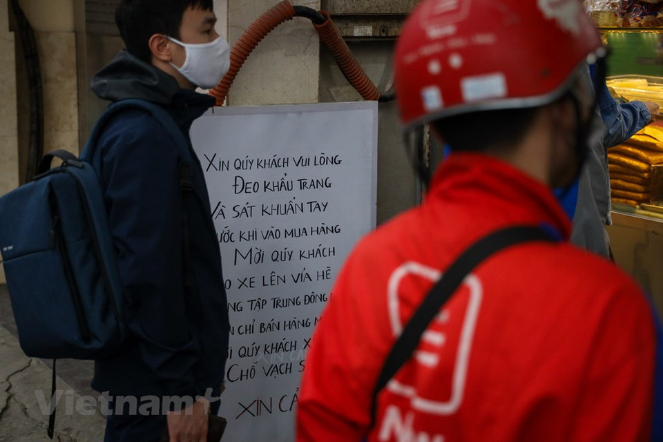  正式放宽社交距离措施，首都河内的生活在逐渐恢复中。河内金马街上一家著名面包店也挂牌，提醒人们在购物之前需要佩戴口罩和使用杀菌洗手液洗手。世界卫生组织西太平洋地区事务负责人葛西武（Takeshi Kasai）高度评价越南政府所采取的疫情防控措施，其中群众遵守社交距离规定为越南取得胜利作出了巨大贡献。Vietnam+记者 明山 摄