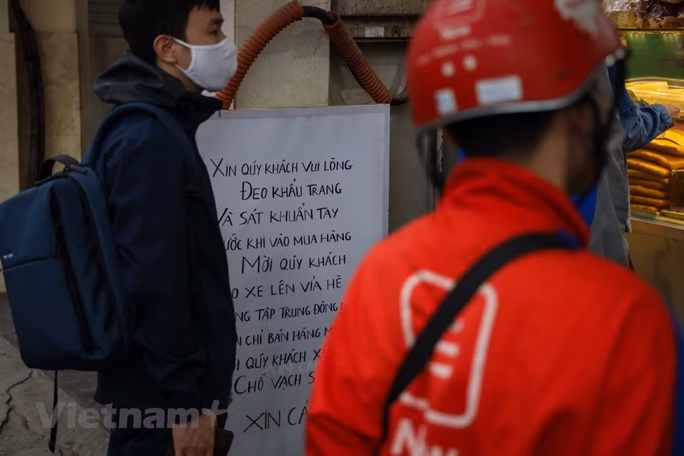  正式放宽社交距离措施，首都河内的生活在逐渐恢复中。河内金马街上一家著名面包店也挂牌，提醒人们在购物之前需要佩戴口罩和使用杀菌洗手液洗手。世界卫生组织西太平洋地区事务负责人葛西武（Takeshi Kasai）高度评价越南政府所采取的疫情防控措施，其中群众遵守社交距离规定为越南取得胜利作出了巨大贡献。Vietnam+记者 明山 摄