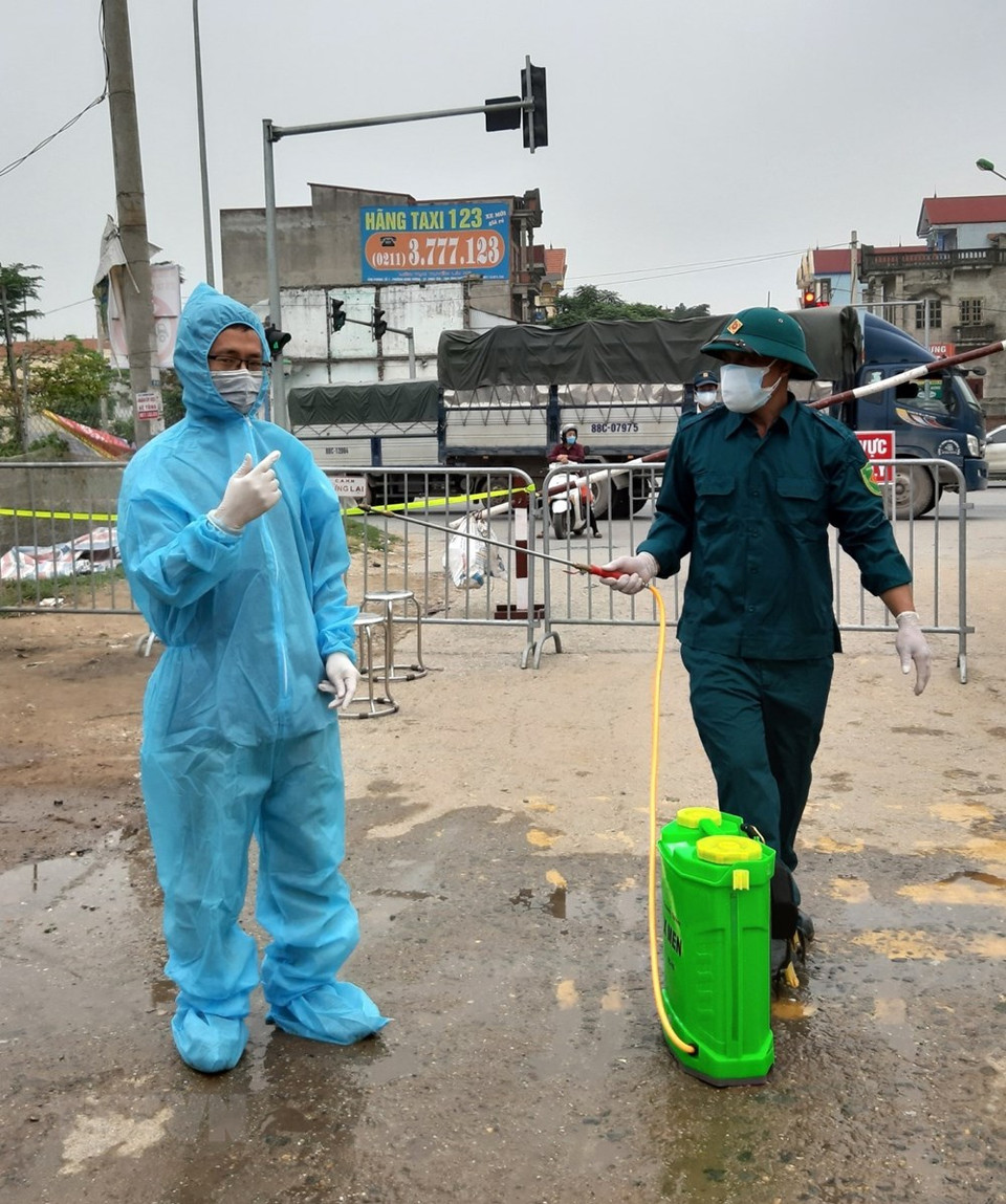 越通社摄影编辑部记记者名岚在河内糜泠县夏雷村疫区工作。图自越通社