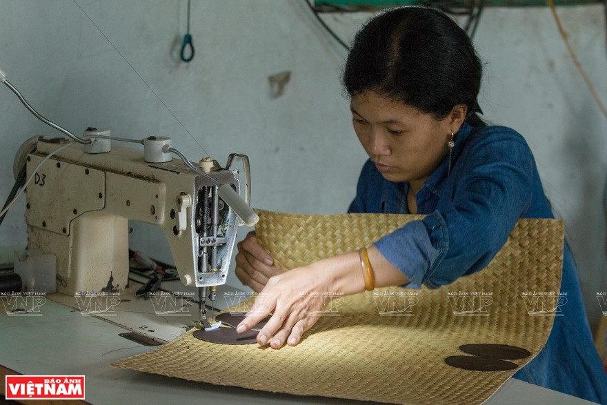 用缝纫机把贴片固定在产品上。越通社记者 成达 摄